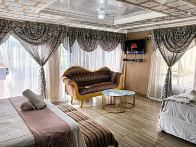 a bedroom with a couch and a chair in a room at Newview bnb and spa in Thulamahashi