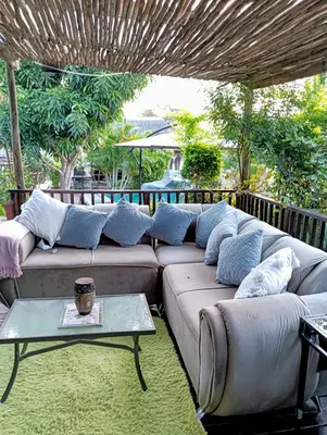 a living room with a couch and a table at Newview bnb and spa in Thulamahashi