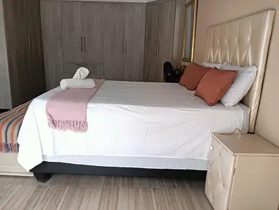 a bedroom with a large bed with white sheets and pillows at Newview bnb and spa in Thulamahashi