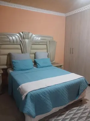 a bedroom with a bed with blue sheets and pillows at Newview bnb and spa in Thulamahashi