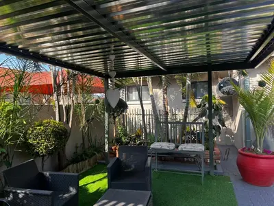 a patio with a wooden pergola with a table and chairs at Guesthouse at 543 in Lebowakgomo