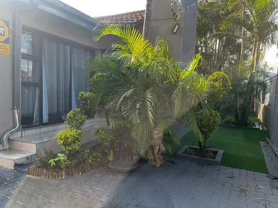 a palm tree in a yard next to a house at Guesthouse at 543 in Lebowakgomo