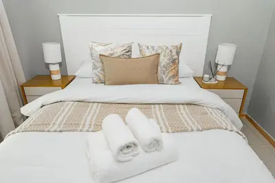 a bedroom with a bed with towels on it at Basambilu Guesthouse in Kempton Park