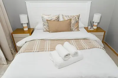 a bedroom with a bed with towels on it at Basambilu Guesthouse in Kempton Park