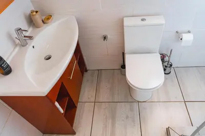 a bathroom with a white toilet and a sink at Basambilu Guesthouse in Kempton Park