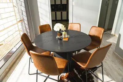 a dining room with a black table and brown chairs at Basambilu Guesthouse in Kempton Park