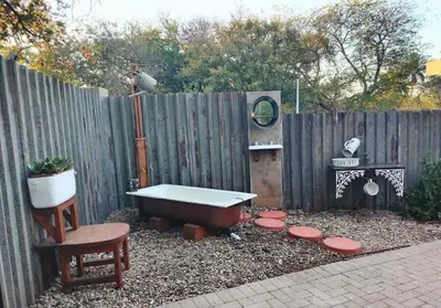 a backyard with a bath tub and a fence at Ukulala Inn in Malelane