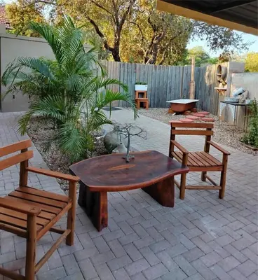 a patio with a wooden table and two benches at Ukulala Inn in Malelane