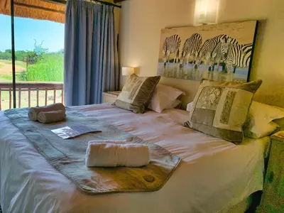a bed with a tray of food on it at Tshikwalo Game Lodge in Klipdrift