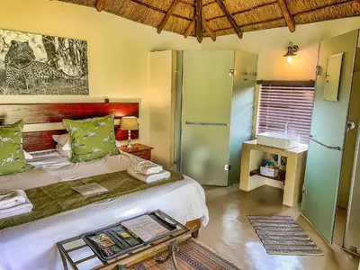 a bedroom with a large bed with a tray on it at Tshikwalo Game Lodge in Klipdrift