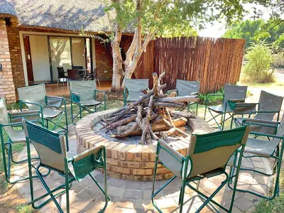 a group of chairs sitting around a fire pit at Tshikwalo Game Lodge in Klipdrift