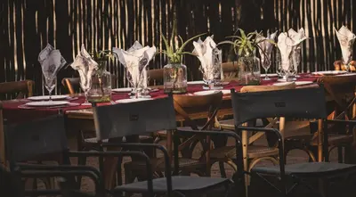 a long table with chairs and vases on it at Tshikwalo Game Lodge in Klipdrift