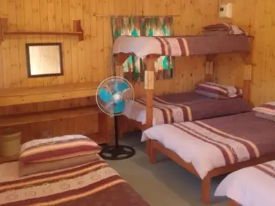 a room with three bunk beds and a fan at Rocky's Wildsplaas in Groblersdal