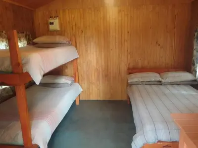 a room with three bunk beds in a cabin at Rocky's Wildsplaas in Groblersdal