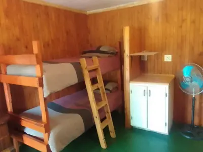 a bedroom with two bunk beds and a desk at Rocky's Wildsplaas in Groblersdal