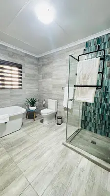 a bathroom with a shower and a tub and a toilet at Sejpro Living at 1 Motse Street in Polokwane