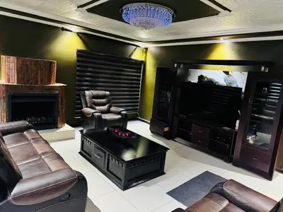 a living room with a flat screen tv and leather furniture at Sejpro Living at 1 Motse Street in Polokwane