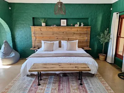 a bedroom with a large bed with a wooden headboard at Cherry Nest in Dullstroom