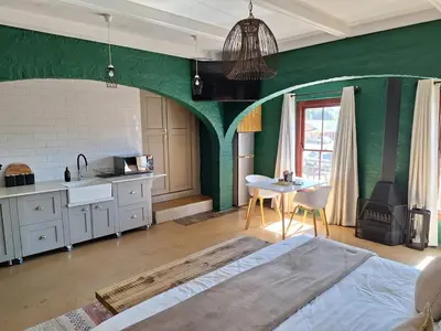 a kitchen with green walls and a bed in a room at Cherry Nest in Dullstroom