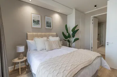 a bedroom with a large bed with white sheets and pillows at Hospitality at Waterfall City - Ellipse Waterfall in Midrand