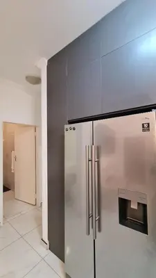 a kitchen with a stainless steel refrigerator and cabinets at NO LOADSHEDDING 1 Bedroom Apartment in Trichardt