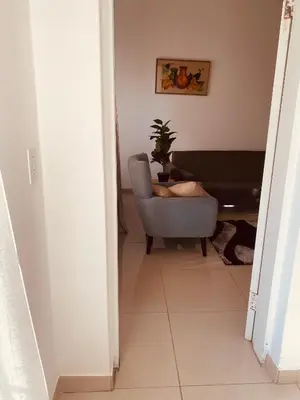 a hallway with a chair and a potted plant at khayelihle guest house in Benoni