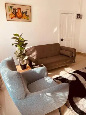 a living room with a couch and a chair at khayelihle guest house in Benoni