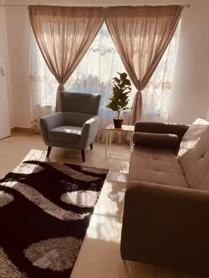 a living room with a couch and a chair at khayelihle guest house in Benoni