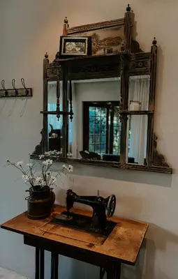 an old sewing machine sitting on a table in front of a mirror at The Garden Den in Nelspruit
