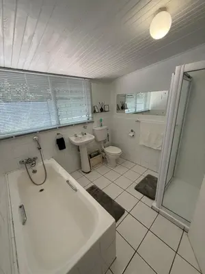 a bathroom with a tub and a toilet and a sink at The Garden Den in Nelspruit