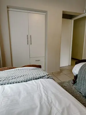 a bedroom with a bed and a closet at The Garden Den in Nelspruit