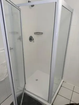 a shower with a glass door in a bathroom at The Garden Den in Nelspruit