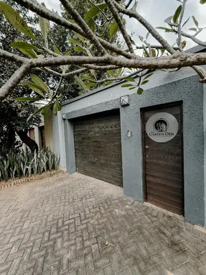 a garage with two doors and a sign on it at The Garden Den in Nelspruit