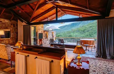 a living room with a large window with a view at Private luxurious suite on Heysbrook Estate halfway to Kruger National Park in Waterval-Onder