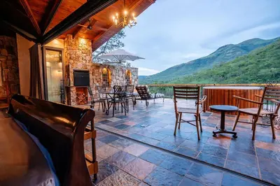 a house with a balcony with chairs and a table at Private luxurious suite on Heysbrook Estate halfway to Kruger National Park in Waterval-Onder