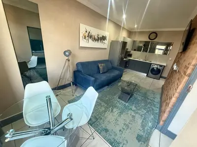 a living room with a blue couch and a table at Junction 502, Menlo Park in Pretoria
