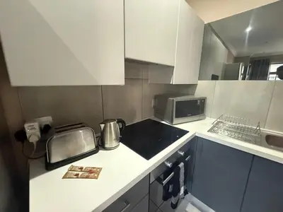 a small kitchen with a stove and a microwave at Junction 502, Menlo Park in Pretoria