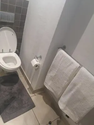 a bathroom with a toilet and two towels at Junction 502, Menlo Park in Pretoria