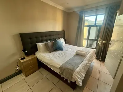 a bedroom with a large bed with a window at Junction 502, Menlo Park in Pretoria