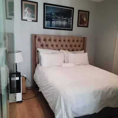 a bedroom with a large bed with white sheets at Luxury Penthouse Apartment Waterfall Midrand in Midrand