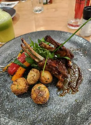 a plate of food with meat and vegetables on a table at Luxury Penthouse Apartment Waterfall Midrand in Midrand