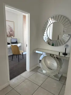a bathroom with a mirror and a desk with a chair at Aesthetic Luxury 2 bedroom penthouse in Pretoria