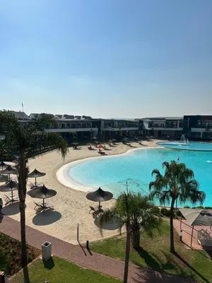a view of a beach with umbrellas and a swimming pool at Aesthetic Luxury 2 bedroom penthouse in Pretoria