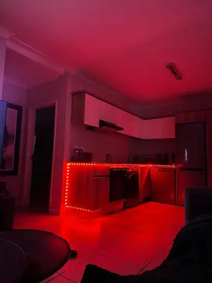 a kitchen with red lighting in a dark room at Aesthetic Luxury 2 bedroom penthouse in Pretoria