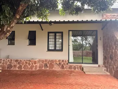 a house with a stone wall and a window at Welgedacht Lodge in Cullinan
