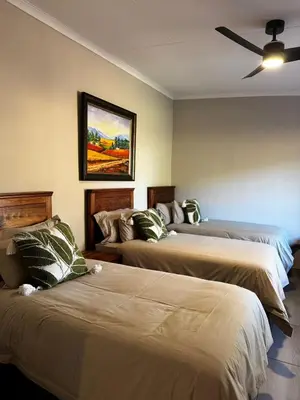 a bedroom with two beds and a ceiling fan at Welgedacht Lodge in Cullinan