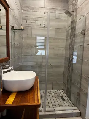 a bathroom with a white sink and a shower at Welgedacht Lodge in Cullinan
