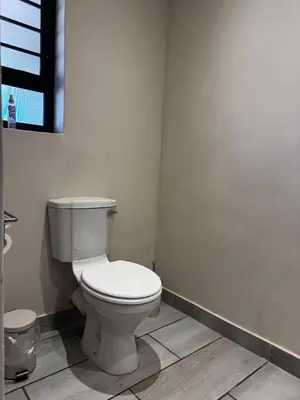 a bathroom with a white toilet in a room at Welgedacht Lodge in Cullinan