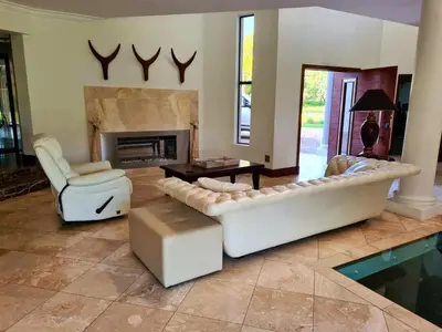 a living room with a couch and a fireplace at The Villa Luxe Hartbeespoort Golf and Wildlife Estate in Hartbeespoort