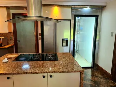 a kitchen with a stove and a glass shower at The Villa Luxe Hartbeespoort Golf and Wildlife Estate in Hartbeespoort